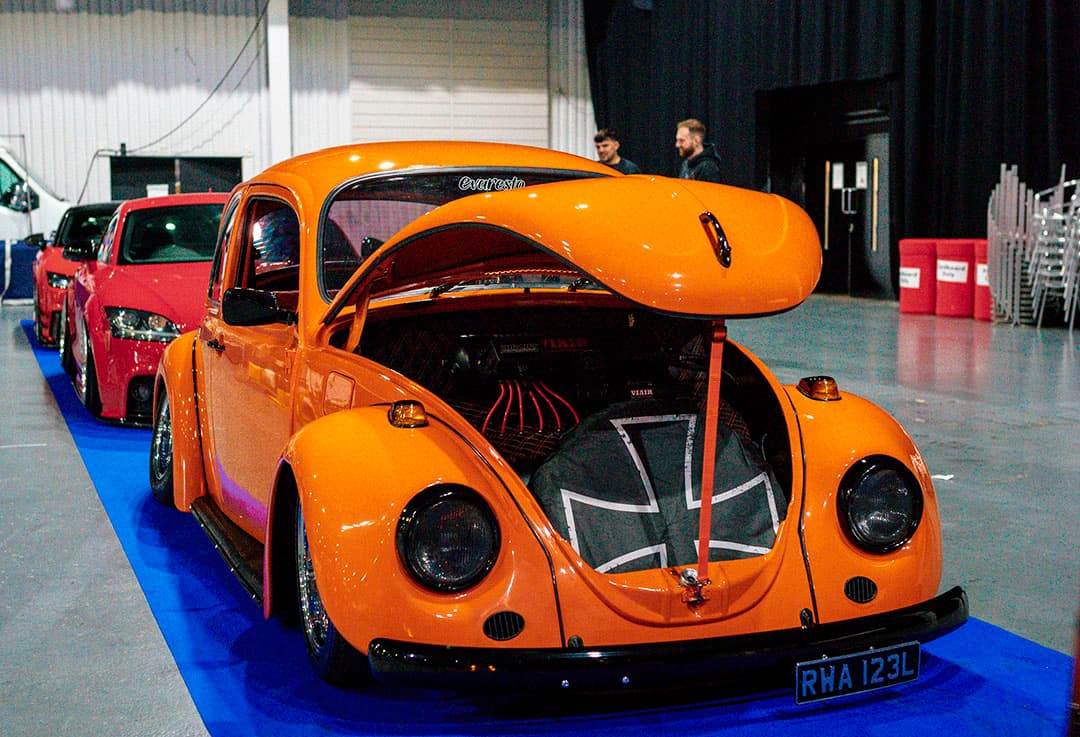 Orange 1970s VW beetle vehicle featured at Ultimate Dubs UK 2024 with Air Lift Performance